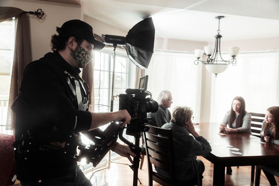 Camera operator filming an actress on a lit commercial set