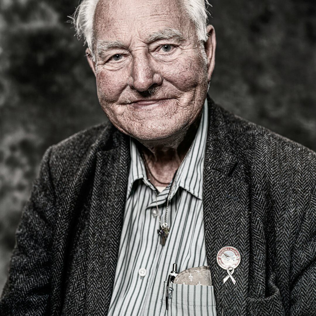 Studio portrait of a grey-haired senior man